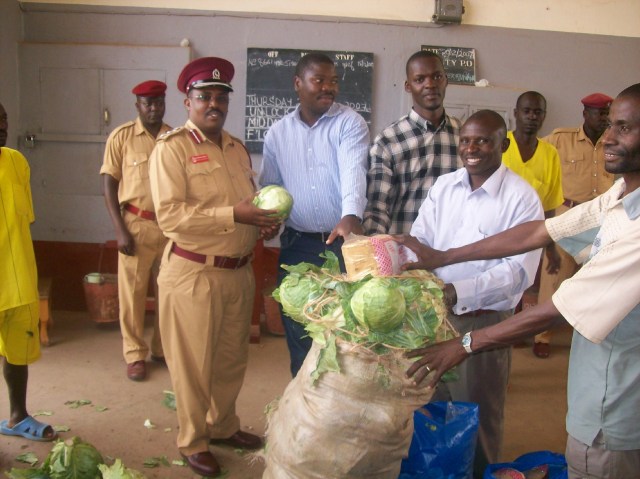 John Mugabi (in blue next to guard) bringing food supplies to a prison