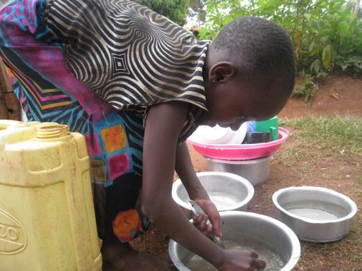 Nkumba girl doing dishes Nkumba girl doing dishes